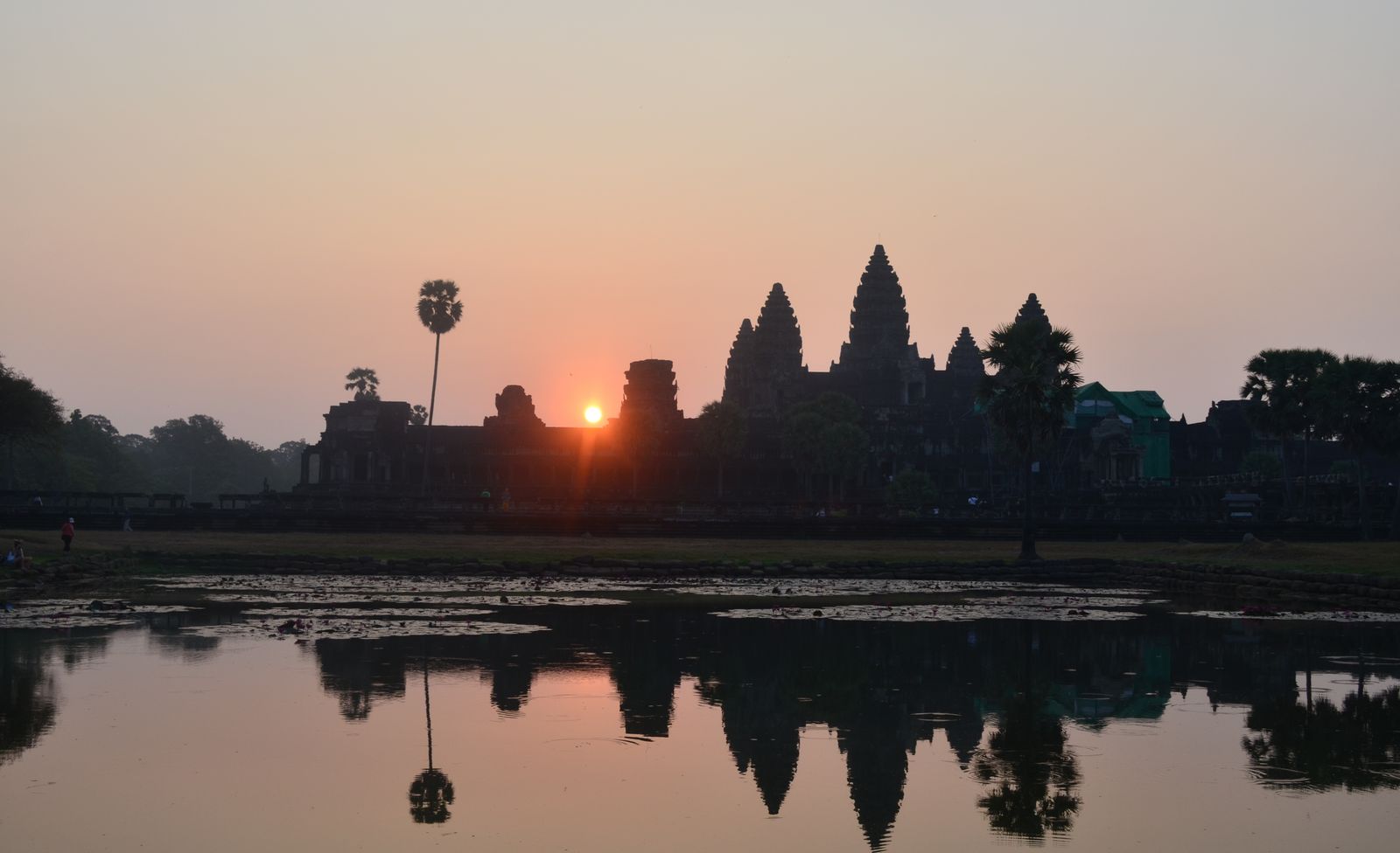 Torres de Angkor Wat refletidas na água durante o amanhecer, no Camboja