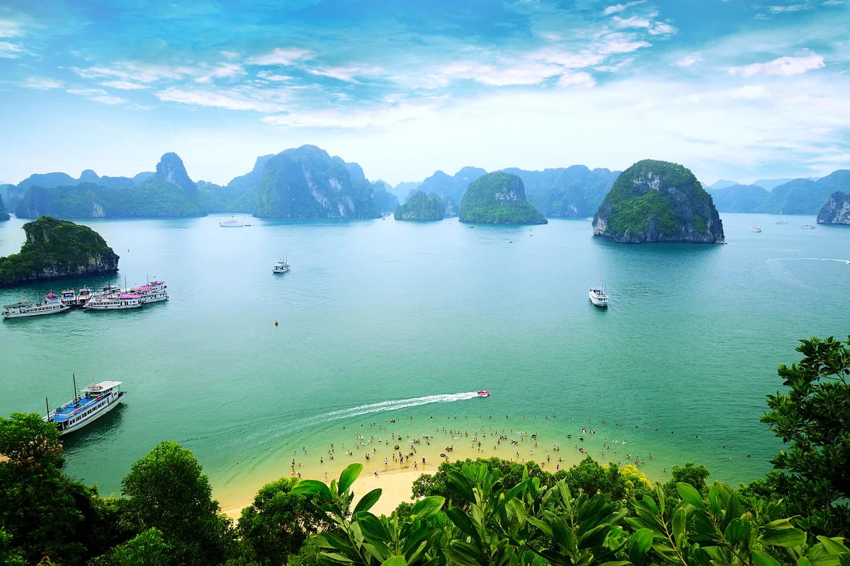 Formações calcárias e embarcações na Baía de Ha Long, Vietnã