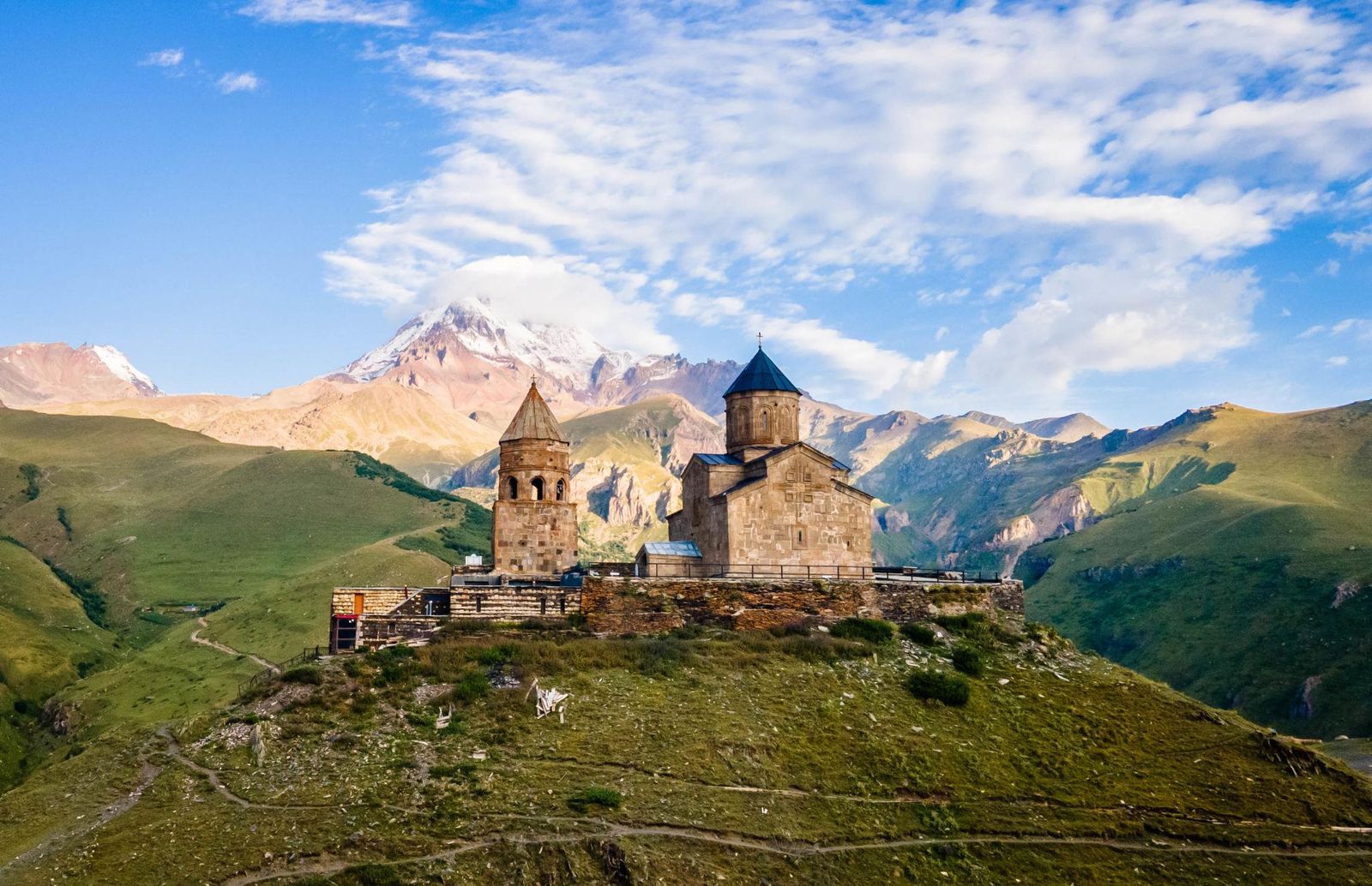 Igreja da Trindade de Gergeti diante das montanhas do Cáucaso em Kazbegi, Geórgia