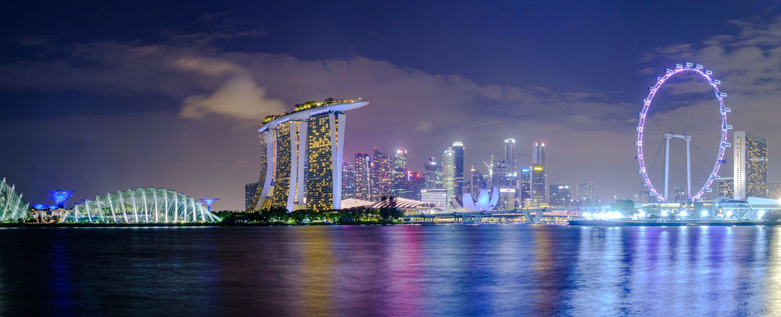 Panorama noturno de Marina Bay, com o Marina Bay Sands, o Singapore Flyer e o horizonte urbano de Singapura