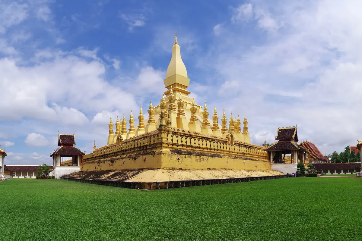 Grande estupa dourada de Pha That Luang sob o céu azul em Vientiane, Laos