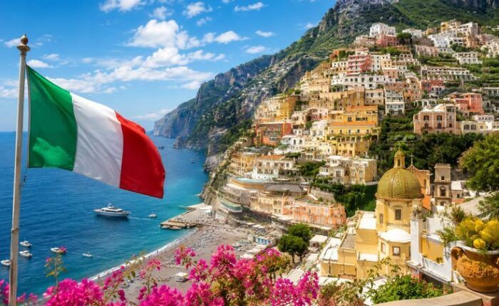 Bandeira da Itália diante da paisagem costeira de Positano, na Costa Amalfitana