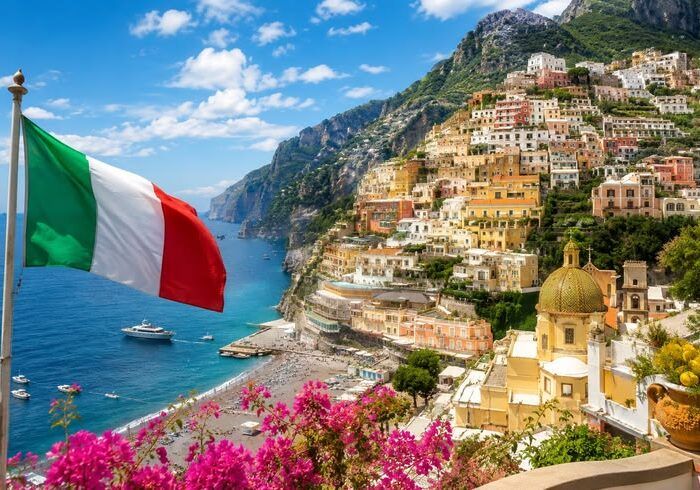 Bandeira da Itália diante da paisagem costeira de Positano, na Costa Amalfitana