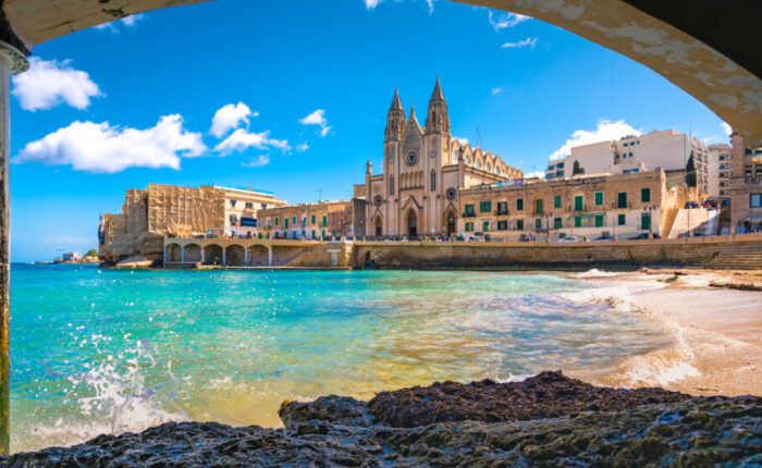 Vista costeira de Malta com igreja e construções históricas