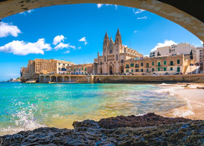 Vista costeira de Malta com igreja e construções históricas
