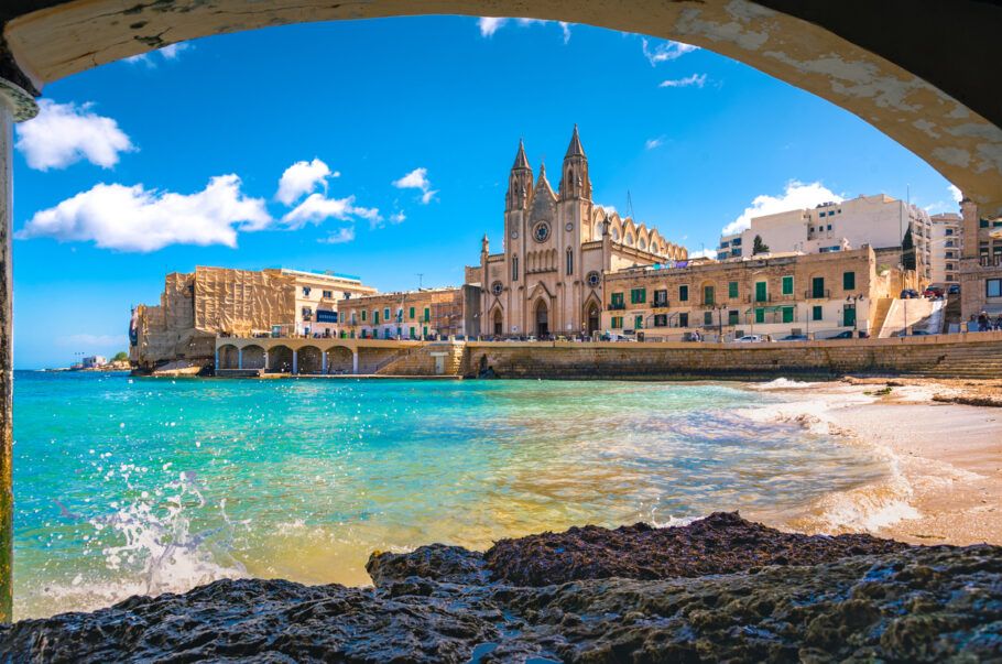 Vista costeira de Malta com igreja e construções históricas