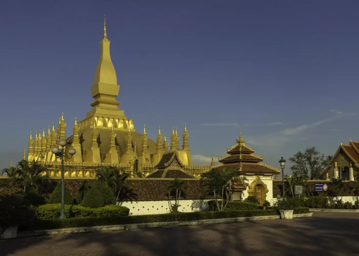 Pha That Luang iluminada em Vientiane, Laos, sob o céu azul