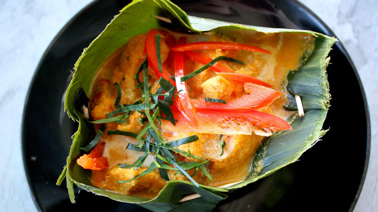 Fish amok servido em folha de bananeira, prato tradicional do Camboja