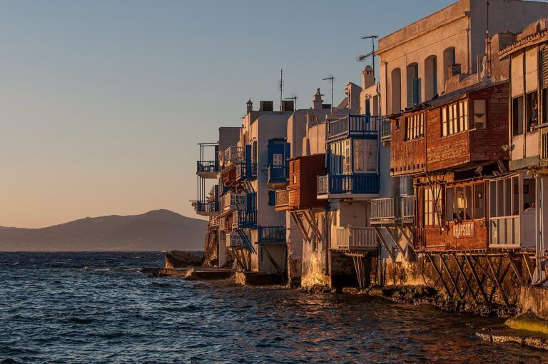Mykonos ao entardecer, com casas brancas, moinhos e o mar Egeu