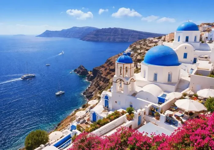 Casas brancas e cúpulas azuis de Santorini diante do Mar Egeu