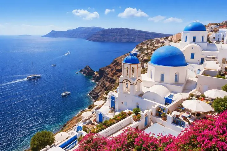 Casas brancas e cúpulas azuis de Santorini diante do Mar Egeu