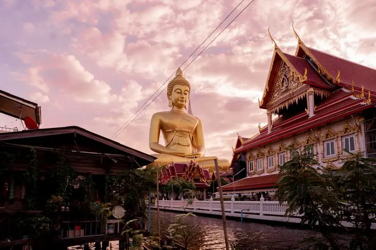 Estátua de Buda junto a um templo em Bangkok, Tailândia