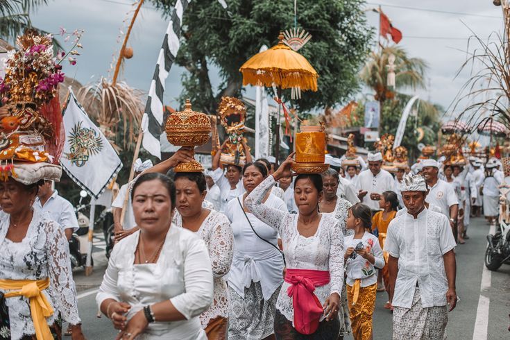 Participantes de uma procissão religiosa em Bali carregam objetos cerimoniais.