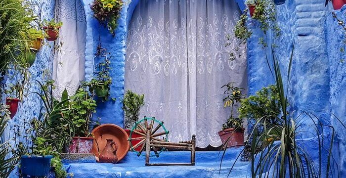 Pátio e paredes azuis em Chefchaouen, Marrocos