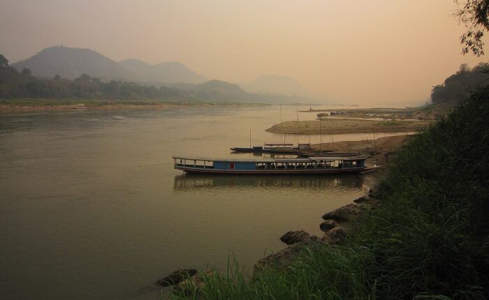 Rio Mekong em Luang Prabang, com margens arborizadas ao fundo.