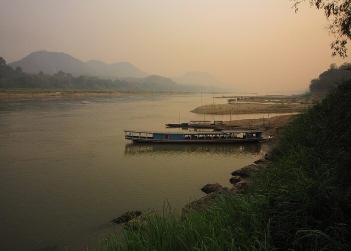 Rio Mekong em Luang Prabang, com margens arborizadas ao fundo.