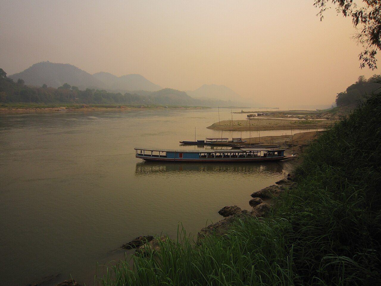 Rio Mekong em Luang Prabang, com margens arborizadas ao fundo.