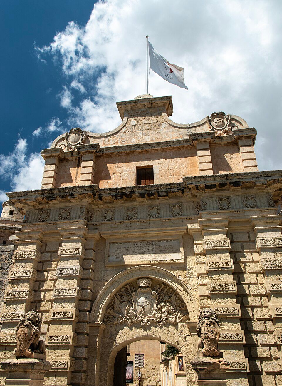 Porta monumental de Mdina, em Malta, com arco de entrada e decoração em pedra.