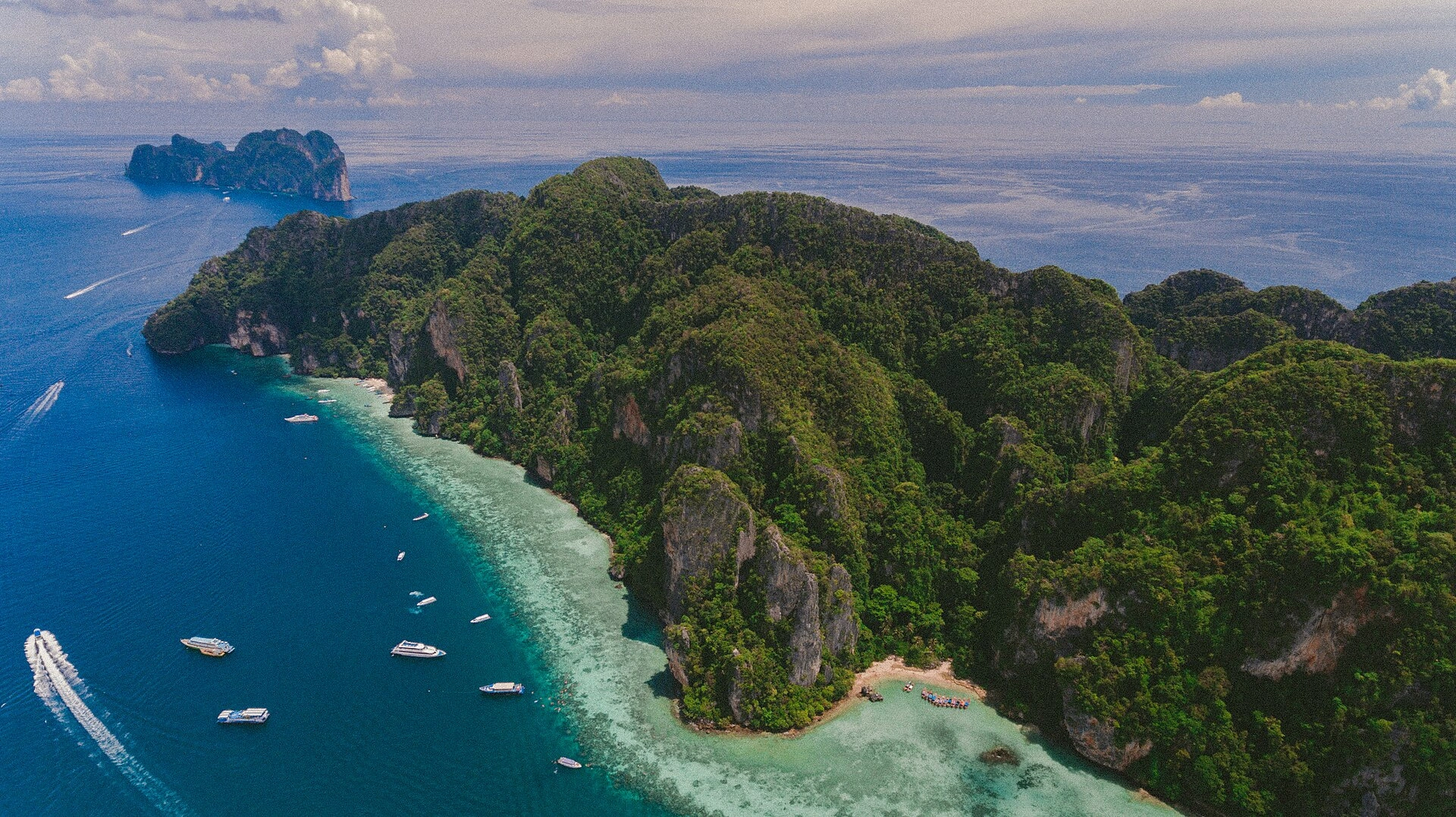 Vista aérea das Ilhas Phi Phi, com relevo calcário, vegetação e embarcações.