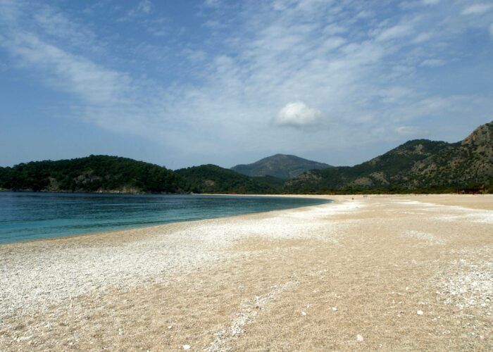Praia de Ölüdeniz, na região de Fethiye, com enseada e montanhas ao fundo