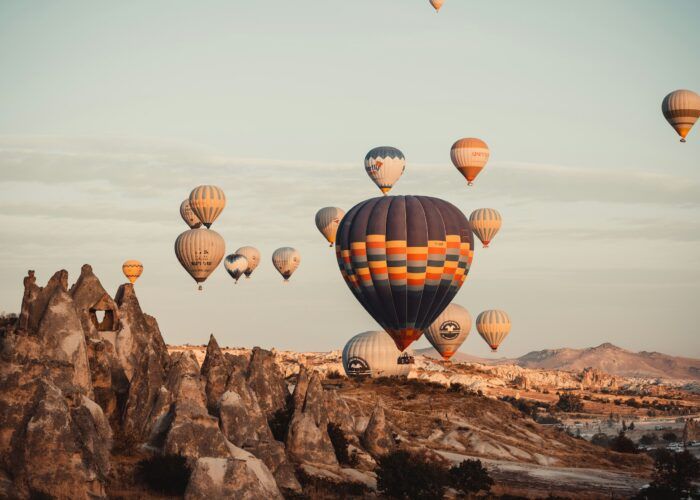 Formações rochosas e balões na Capadócia ao amanhecer. Voo de balão opcional, não incluído na base do roteiro.