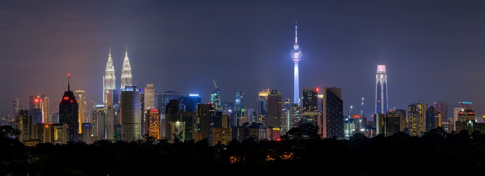 Vista noturna de Kuala Lumpur, com as Petronas Towers à esquerda e a KL Tower à direita.