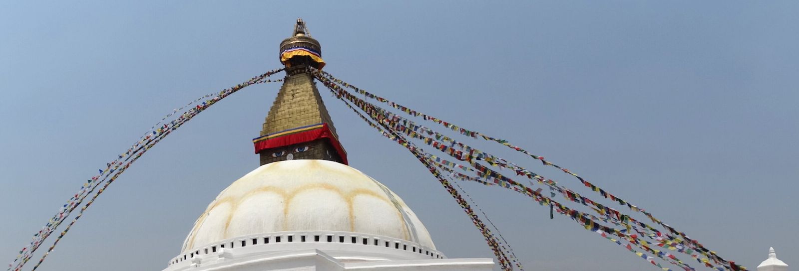 Cúpula e torre da estupa de Boudhanath com bandeiras de oração, no vale de Kathmandu