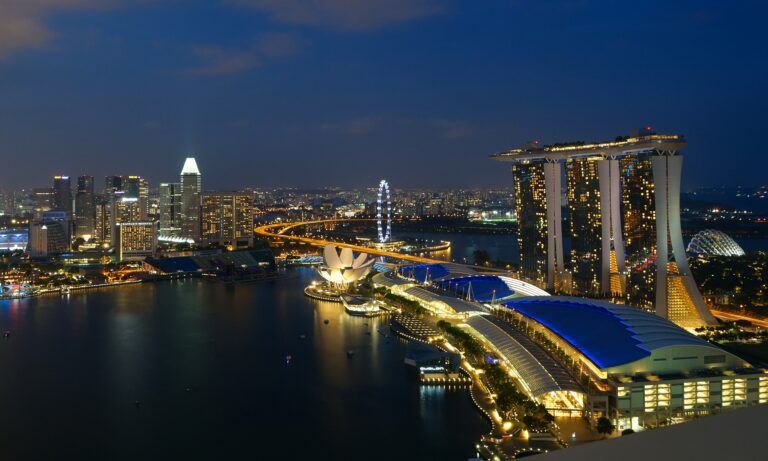 Marina Bay à noite, com o Marina Bay Sands à direita, o ArtScience Museum e a Singapore Flyer iluminados junto à baía.