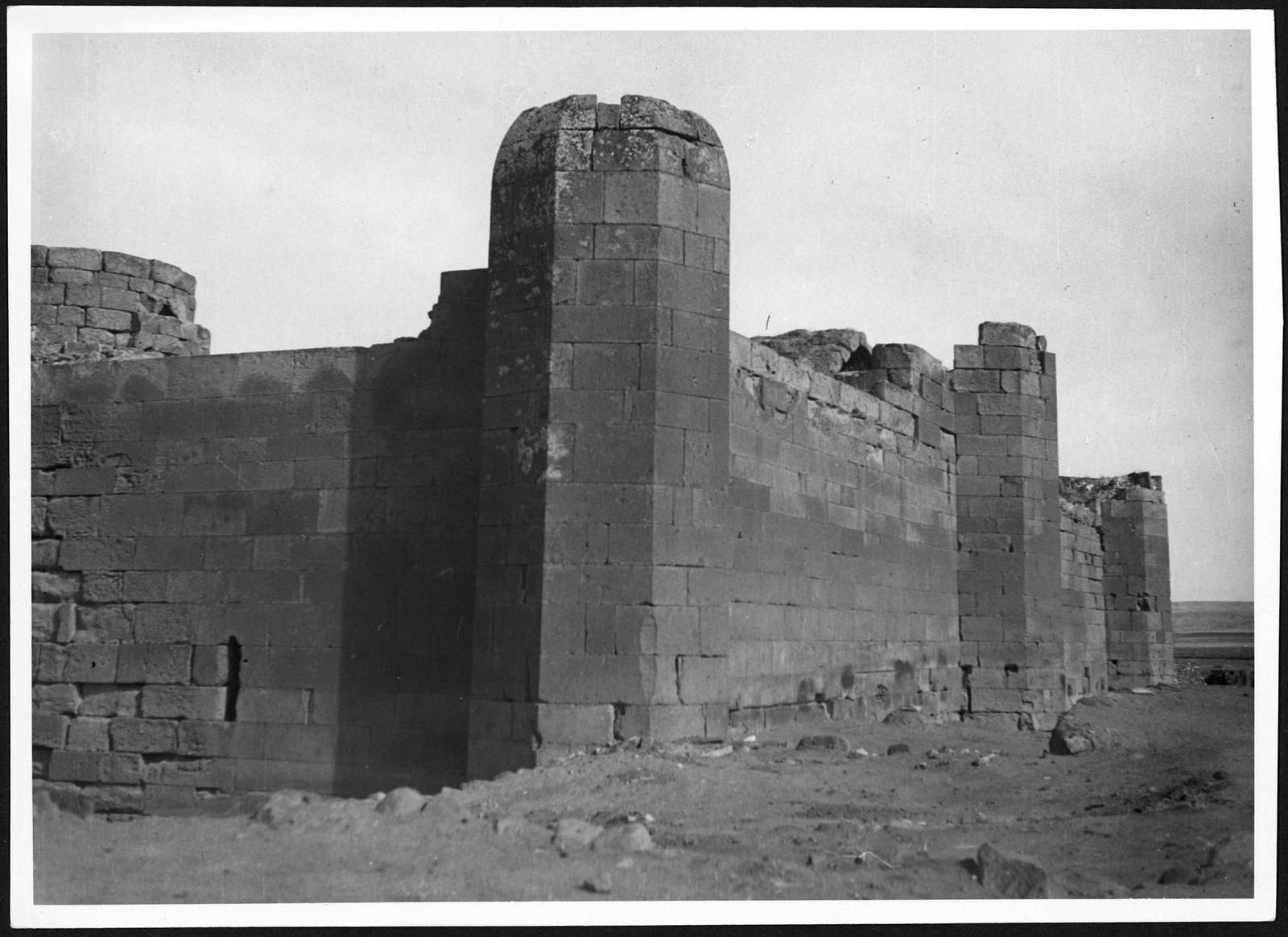Fotografia em preto e branco das paredes de pedra e dos contrafortes de Sultan Han, em 1933–1934.